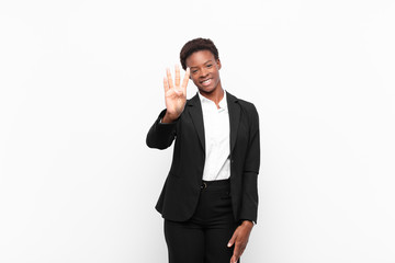 young pretty black womansmiling and looking friendly, showing number four or fourth with hand...