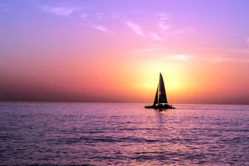Foto auf Acrylglas Ein Segelboot vor einem Sonnenuntergang © Melvin