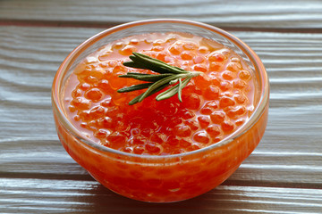 Red caviar in a glass bowl close-up. A light gourmet snack. Salmon caviar for breakfast.
