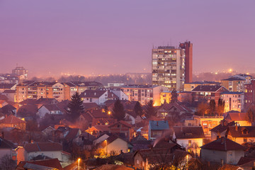 Purple color cityscape of Pirot, Serbia during blue hour, skyscraper, buildings and houses lighten by city lights