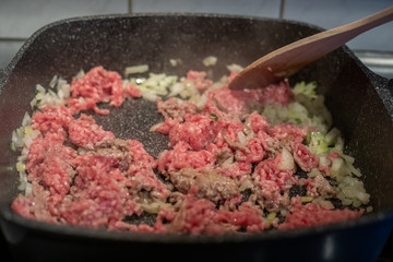 Ground beef browning in pot with onions