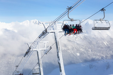 Fototapeta na wymiar Whistler, British Columbia, Canada. People going up the mountain on a Chairlift during a vibrant and sunny winter day.