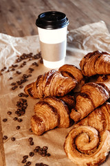 Cup of black freshly brewed coffee. Crispy croissant, breakfast in cafe.