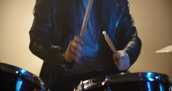 A professional drummer is playing rock music with band. Experienced musician is beginning the performance in club - music concept 4k footage