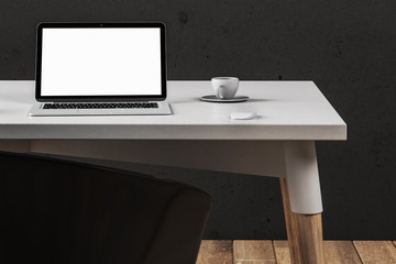 Office with blank laptop screen