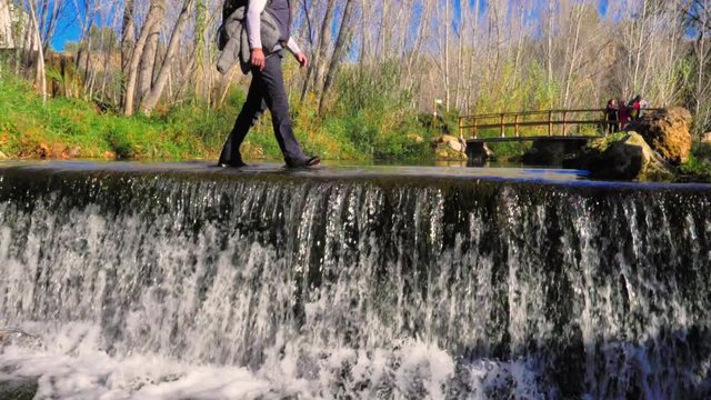 excursionista andando sobre las aguas de cascada de r&iacute;o