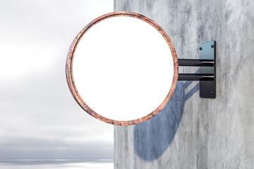 Blank round signboard hanging on grey wall.