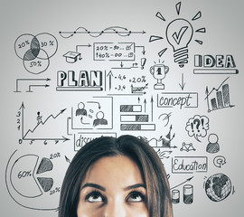 Businesswoman looking on drawing global marketing plan over head