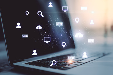 Laptop with glowing social network hologram.