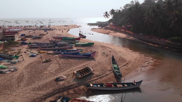 Aerial view of a small Indian river with wooden fishing boats on Baga Beach, Goa, India