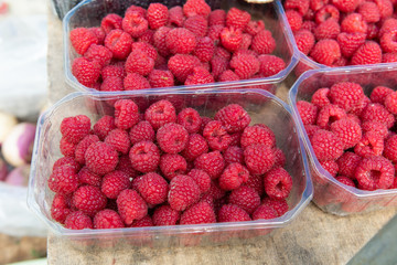 Fresh healthy raspberries in plastic box for sale at Municipal Market in Armacao de Pera in Portugal.