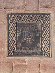 Manhole cover on pavement with patterns