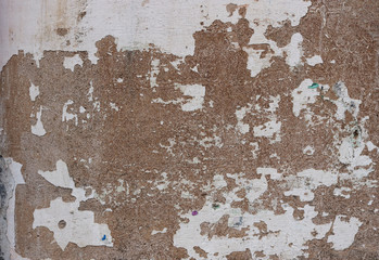 old white and brown wall with peeling paint and chipped - rough texture for a background