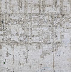 messy white wall with irregular lines from glue of posters in the surface and contrast of rough textures - blank background