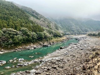 Japanese mountains and river on a cloudy day.