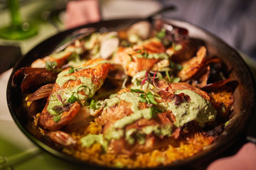 Delicious Seared Salmon with Green Sauce, Mussels, Shrimp and  Garnish Served on Homey Country Style Plate