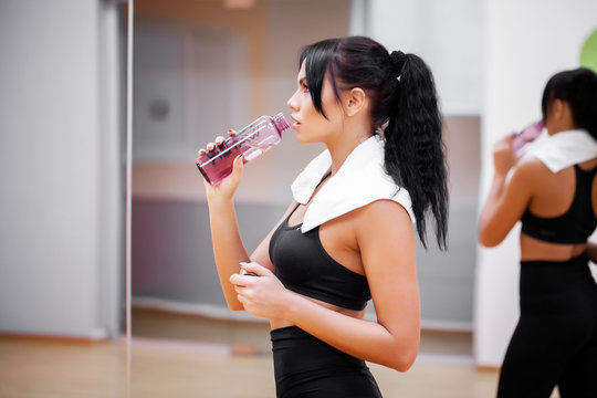 Fitness Girl. Young beautiful woman in sportswear drinking water.