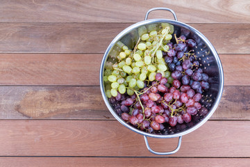 Three variety of grapes in metal bowl  on wooden table