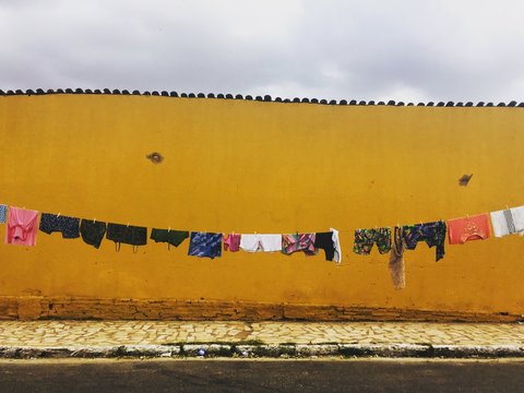 Clothes Drying Outdoors Against Yellow Wall