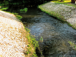 A river surrounded by hills, fields and forests in summer in Russia