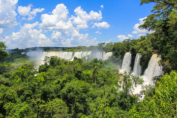 The majestic Iguazu Falls,  on the background of blue sky, one of the wonders of the world