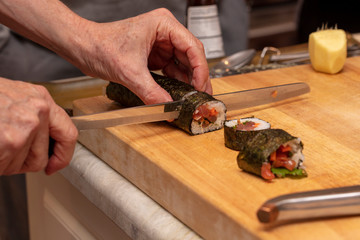 Sushi roll being sliced in a demonstaration class