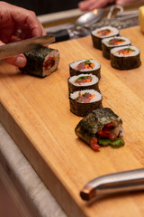 Sushi roll being sliced in a demonstaration class