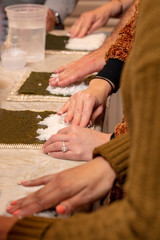 Sushi roll being made in a demonstaration class and students participating