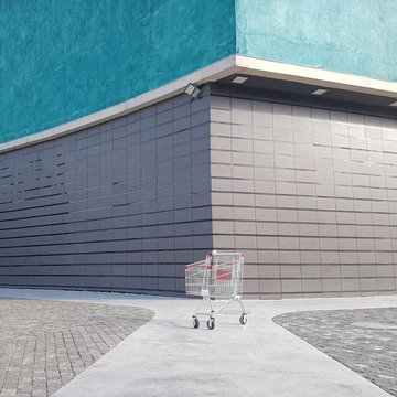 Shopping cart on footpath against building