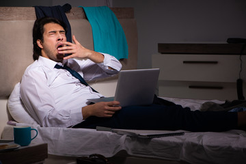 Young employee working at home after night shift