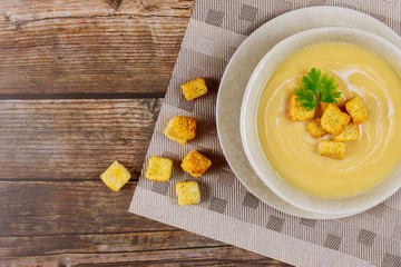 Homemade creamy pea soup with croutons on table.