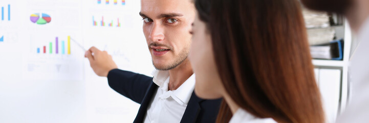 Group of people deliberate on white board problem in office closeup. Graph consult idea participate...