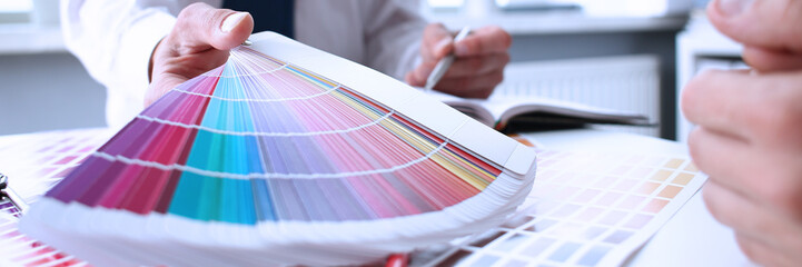Employee refueling cartridge service holds magnifying glass in hand. Color print of pantone...