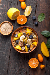 Fresh quinoa organic fruit salad in bowl on wooden  background. Helthy superfood detox concept.  Vegan/vegetarian food. Space for text. Top view