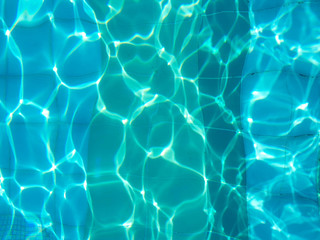 Blue romantic rippling water surface with sun glare. The glare from the sun on the waves