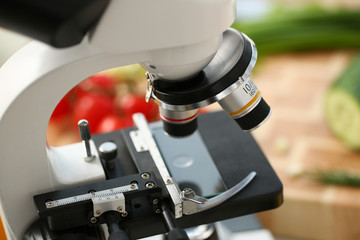 Fototapeta na wymiar Microscope head on kitchen background vegetables concept nitrates