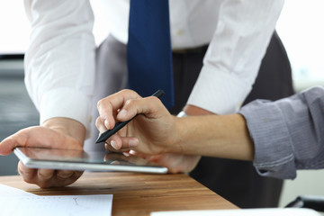 Close-up of manger and customer speaking about condition of agreement. Client signing electronic...