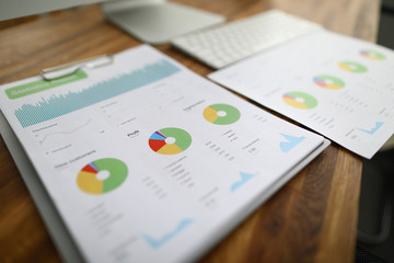 Close-up of financial statement lying on wooden table. Annual report or presentation with...
