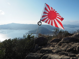 Fototapeta premium 江田島古鷹山山頂の旭日旗（Rising Sun Flag at the summit of Furutakayama mountain, Etajima island, Hiroshima) 