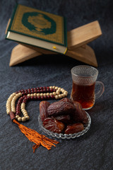 food Ramadan Sweets mixed of dried fruits and nuts Glass Tea with  rosary and the Quran on the table,