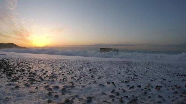 Lever de soleil et vagues sur une plage de la mer m&eacute;diterran&eacute;e dans la ville de Nice en France