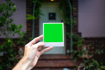 Holding Polaroid in front of house door (landscape)