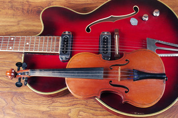 Jazz electric guitar and violin on a wooden texture.
