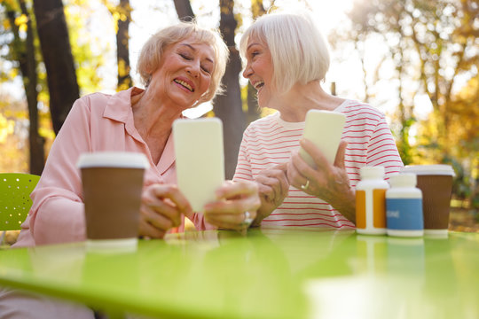 Happy friends showing each other their new devices