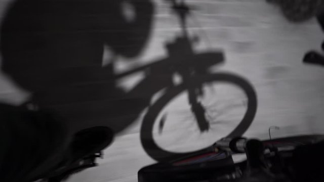 man rides a bicycle pedal view shadow of a bicycle, night 4k