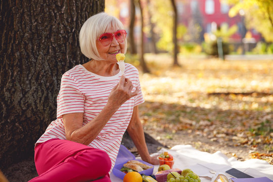Happy woman enjoying her picnic in the park