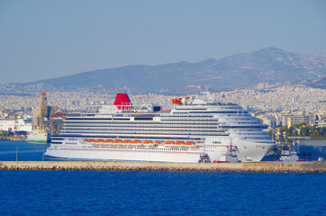 Huge cruiseship liner or cruise ship vessel with water slides and skyline of Athens in Greece while...