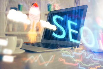 Multi exposure of table with computer and seo drawing hologram. Search optimization concept.