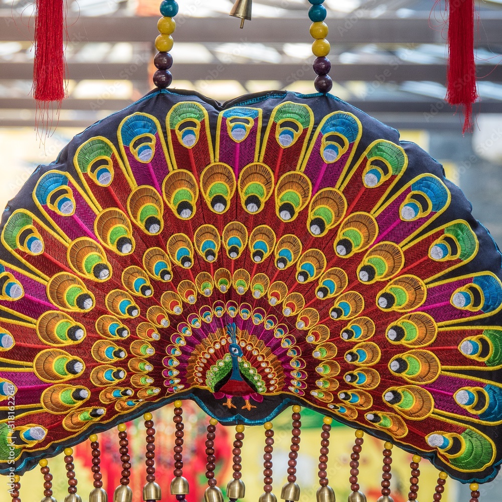 Poster closeup shot of a statue of the multicolored feathers of a peacock
