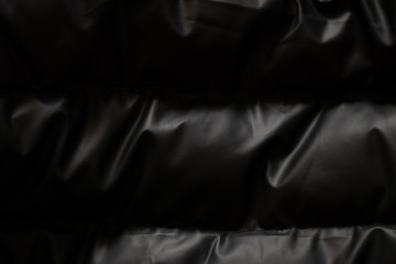 background of a black puffer jacket close up